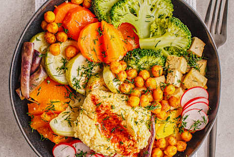 Зерновая чаша, загруженная нутом, тофу, брокколи, моркови и хумуса