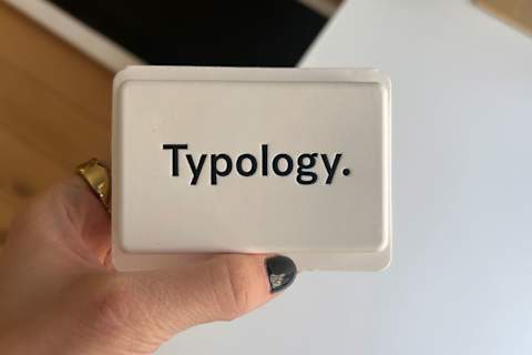 Фотография Typology Bar в упаковке в руке писателя Фотография Typology Bar в упаковке в руке писателя